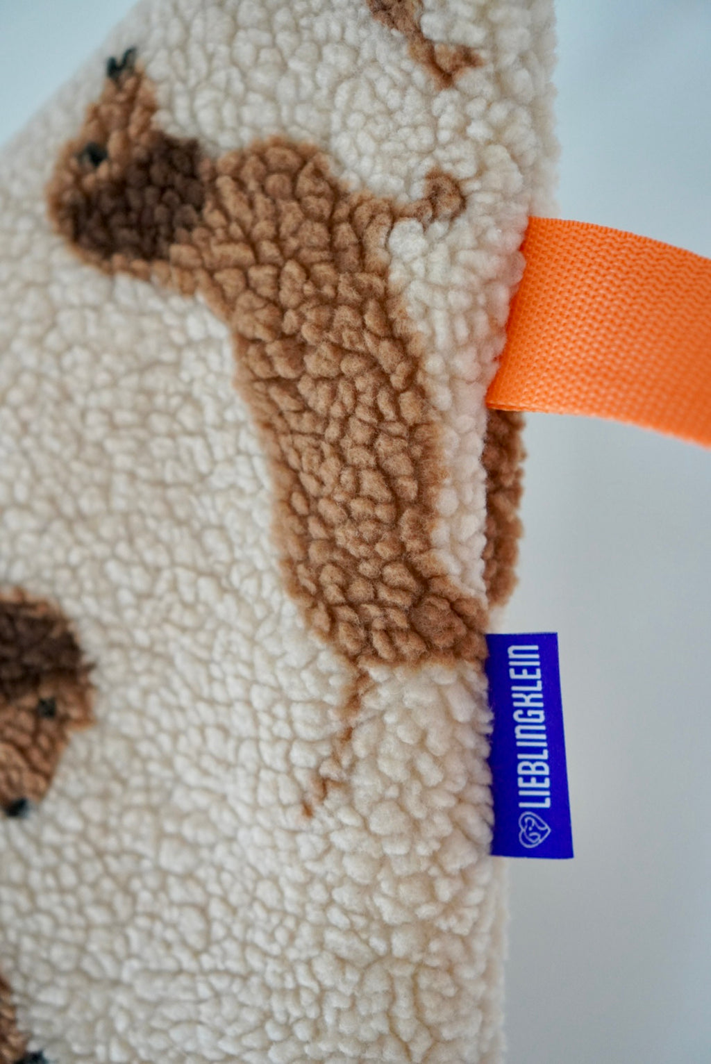 Detail PLACE Hundedecke Dackel: Teddy mit Dackelmuster, lieblingklein Label und orangener Gurt