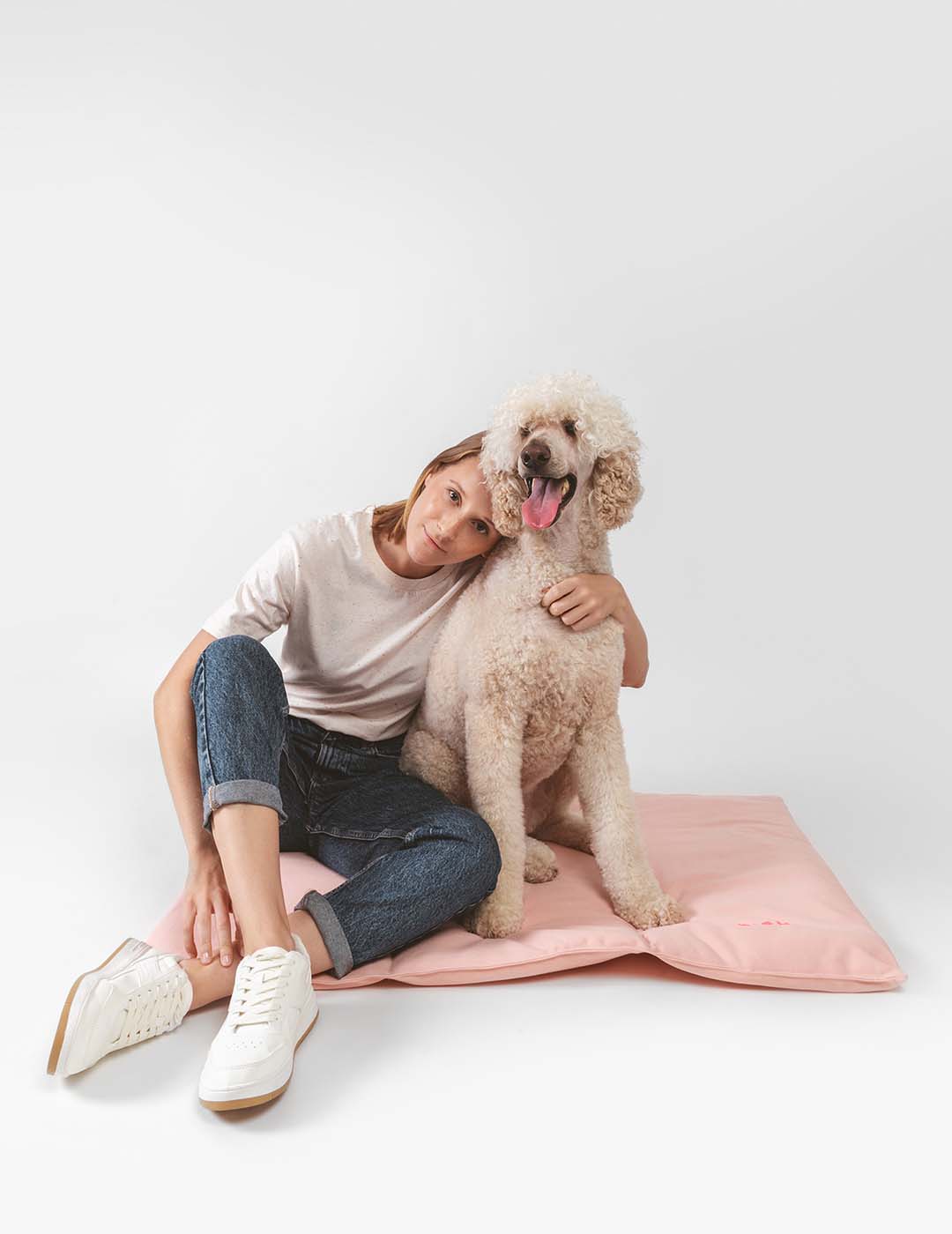 Hund auf dem Nomad Bed von Qisu in zartem Rosa – stilvoller Wohlfühlplatz für unterwegs