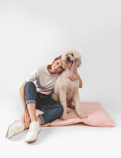 Hund auf dem Nomad Bed von Qisu in zartem Rosa – stilvoller Wohlfühlplatz für unterwegs