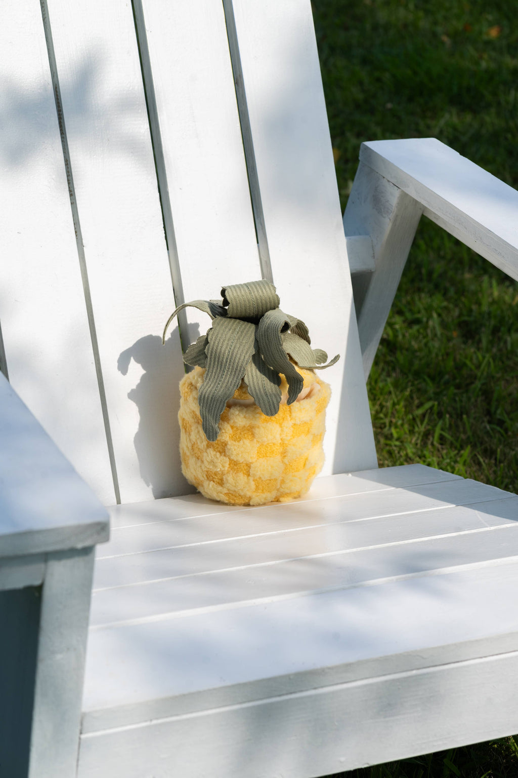 PINEAPPLE POP Ananas-Spielzeug auf weißem Stuhl – Sommerfeeling für Hunde