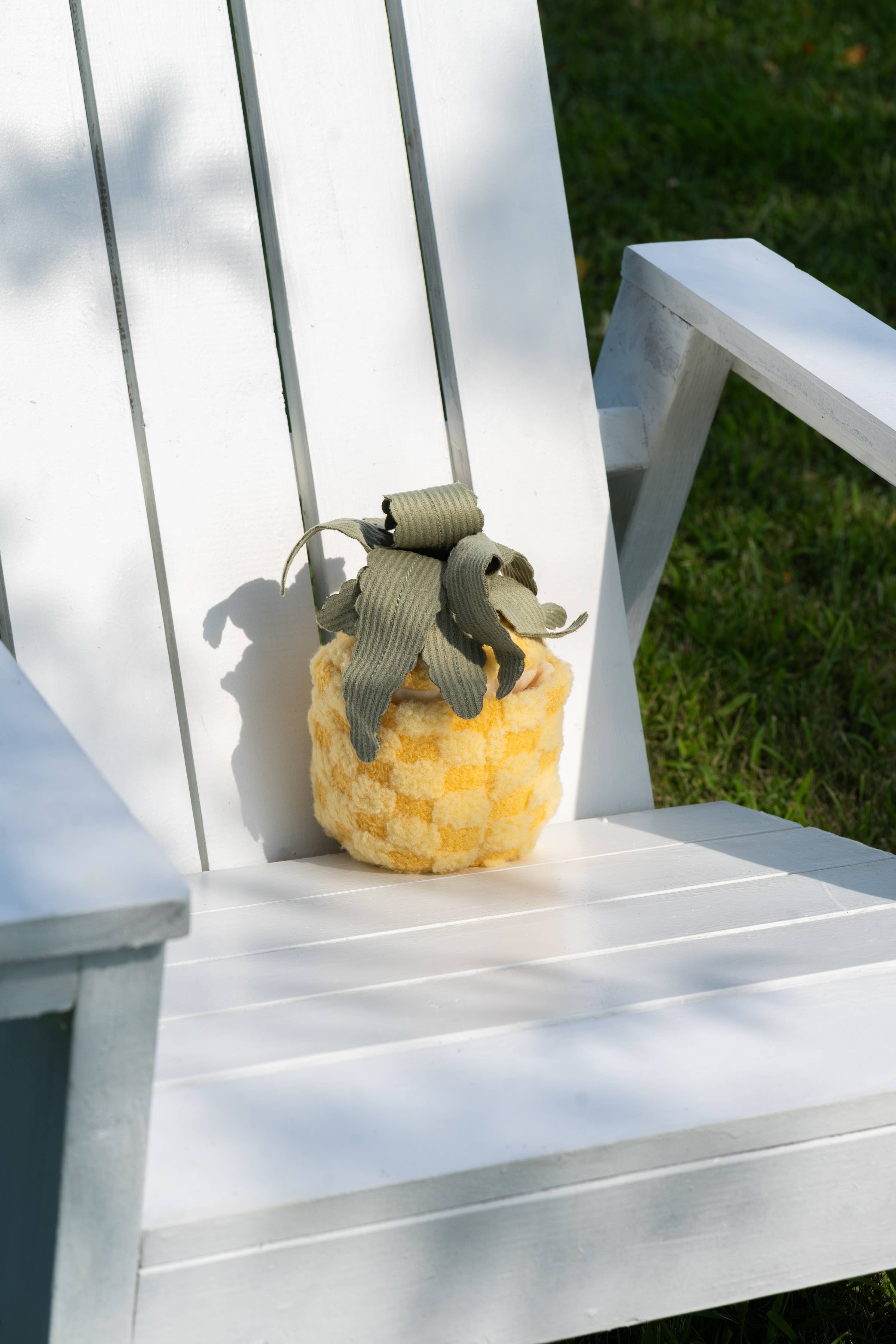 PINEAPPLE POP Ananas-Spielzeug auf weißem Stuhl – Sommerfeeling für Hunde